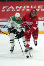 Dallas Stars center Jason Dickinson, left, and Detroit Red Wings defenseman Marc Staal, right, battle for the puck in the first period of an NHL hockey game Thursday, April 22, 2021, in Detroit. (AP Photo/Paul Sancya)