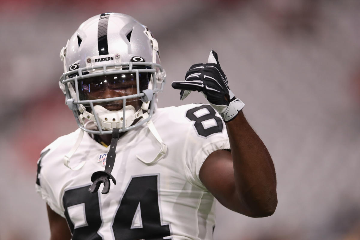 An Oakland Raiders player holds up a helmet at the start of a NFL preseason  football game again …