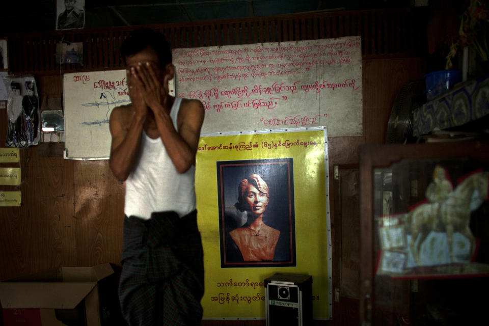 In this Sept. 1, 2012 photo, an HIV patient rubs his face near a poster showing a sculpture of the Nobel Peace Prize laureate Aung San Suu Kyi at an HIV/AIDS center founded by a member of Myanmar's opposition party National League for Democracy, led by Suu Kyi, on the outskirts of Yangon. Following a half century of military rule, care for HIV/AIDS patients in Myanmar lags behind other countries. Half of the estimated 240,000 people living with the disease are going without treatment and 18,000 are dying from it every year. (AP Photo/Alexander F. Yuan)
