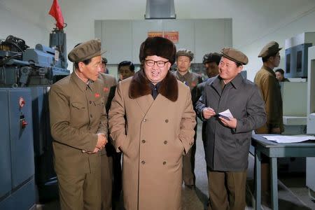 North Korean leader Kim Jong Un (C) smiles during a visit to the Sinhung Machine Plant in this undated photo released by North Korea's Korean Central News Agency (KCNA) in Pyongyang April 1, 2016. REUTERS/KCNA