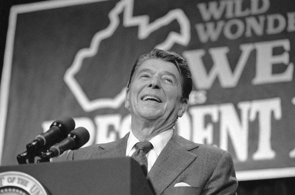 FILE - President Ronald Reagan smiles in front of an outline of the state of West Virginia while addressing a rally at Parkersburg High School in Parkersburg, W.Va., Oct. 29, 1984. (AP Photo/Barry Thumma, File)