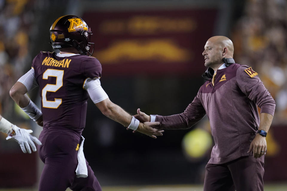 Minnesota head coach P. J. Fleck, right, celebrates with quarterback Tanner Morgan, left, after a touchdown during the first half of an NCAA college football game against New Mexico State, Thursday, Sept. 1, 2022, in Minneapolis. (AP Photo/Abbie Parr)