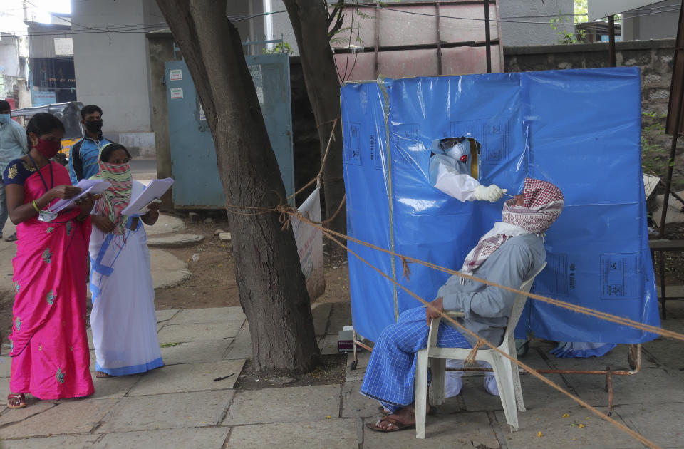 A health worker takes a nasal swab sample to test for COVID-19 in Hyderabad, India, Saturday, Aug. 22, 2020. India has the third-highest caseload after the United States and Brazil, and the fourth-highest death toll in the world. (AP Photo/Mahesh Kumar A.)