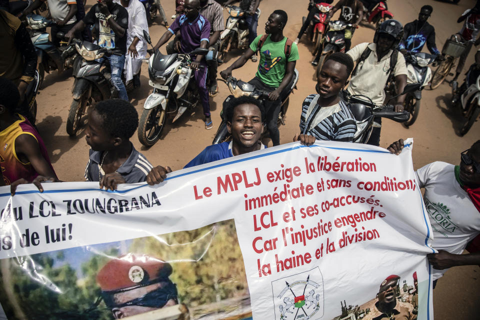 Young men chant slogans against the power of Lieutenant-Colonel Damiba, against France and pro-Russia, in Ouagadougou, Burkina Faso, Friday Sept. 30, 2022. Residents say gunfire rang out early in the morning and the state broadcaster has gone off the air, fueling fears that another coup is underway. The developments Friday come just after coup leader-turned-president, Lt. Col. Paul Henri Sandaogo Damiba, returned from a trip to the U.N. General Assembly. (AP Photo/Sophie Garcia)