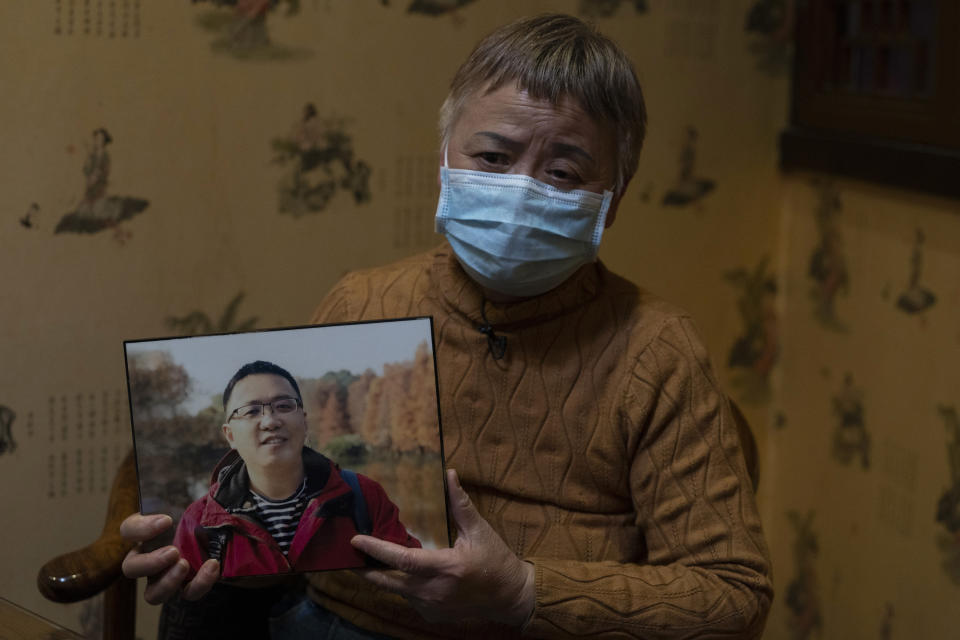 Zhong Hanneng holds a photo of her son, Peng Yi, and talks about his difficulties in getting tested for COVID-19, eventually dying from the disease, in Wuhan in central China's Hubei province on Saturday, Oct. 17, 2020. “There were very, very few tests, basically none. ... if you couldn’t prove you were positive, you couldn’t get admitted to a hospital. ... The doctor said there was nothing that could be done.” (AP Photo/Ng Han Guan)