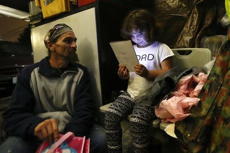 Emma Savage, 6, opens a birthday card given to her by her dad Robert Rowe, 42, at SHARE/WHEEL Tent City 3, outside Seattle, Washington October 12, 2015. REUTERS/Shannon Stapleton/Files