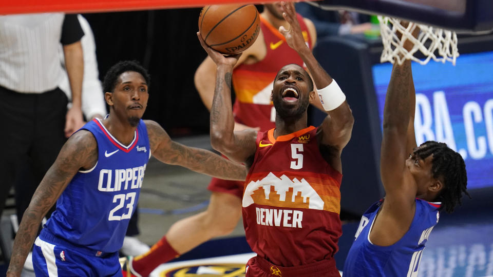 Denver Nuggets forward Will Barton, center, drives to the basket between Los Angeles Clippers guards Lou Williams, left, and Terance Mann during the first half of an NBA basketball game Friday, Dec. 25, 2020, in Denver. (AP Photo/David Zalubowski)
