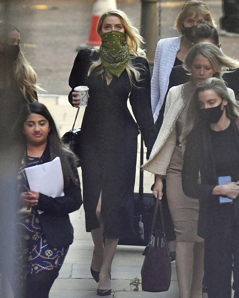 Actress Amber Heard, centre, arrives at the High Court in London for a hearing in Johnny Depp's libel case, Friday July 10, 2020. Depp is back in the witness box at the trial of his libel suit against a tabloid newspaper that called him a "wife-beater" in an April 2018 article that said he'd physically abused ex-wife Amber Heard. Depp strongly denies the allegations. (Victoria Jones/PA via AP)