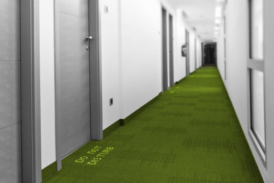 In this computer-generated image made available by Royal Philips NV, Monday, Nov. 18, 2013, a LED sign with glowing lights reading “Do Not Disturb” drives the message home in a fictional hotel corridor. That option is on its way as two European companies, Philips and carpet-maker Desso have developed a system in which colored LEDs are combined with specialized carpets to make tailored hotel signs or directions to airport boarding gates that appear underfoot instead of on walls. (AP Photo/Philips)