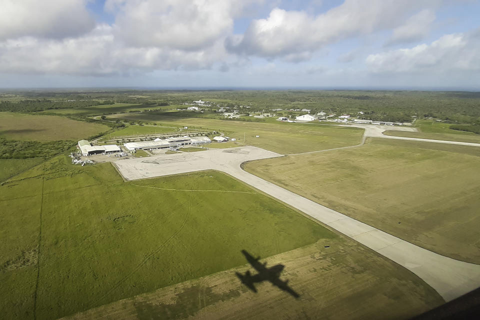 In this photo provided by the New Zealand Defence Force, a shadow of a Hercules aircraft is cast on the ground as it arrives at Tonga's Fuaʻamotu International Airport, near Nukuʻalofa Thursday, Jan. 20, 2022, to deliver aid after a volcano eruption. U.N. humanitarian officials report that about 84,000 people — more than 80% of Tonga's population — have been impacted by the volcano's eruption. (New Zealand Defence Force via AP)