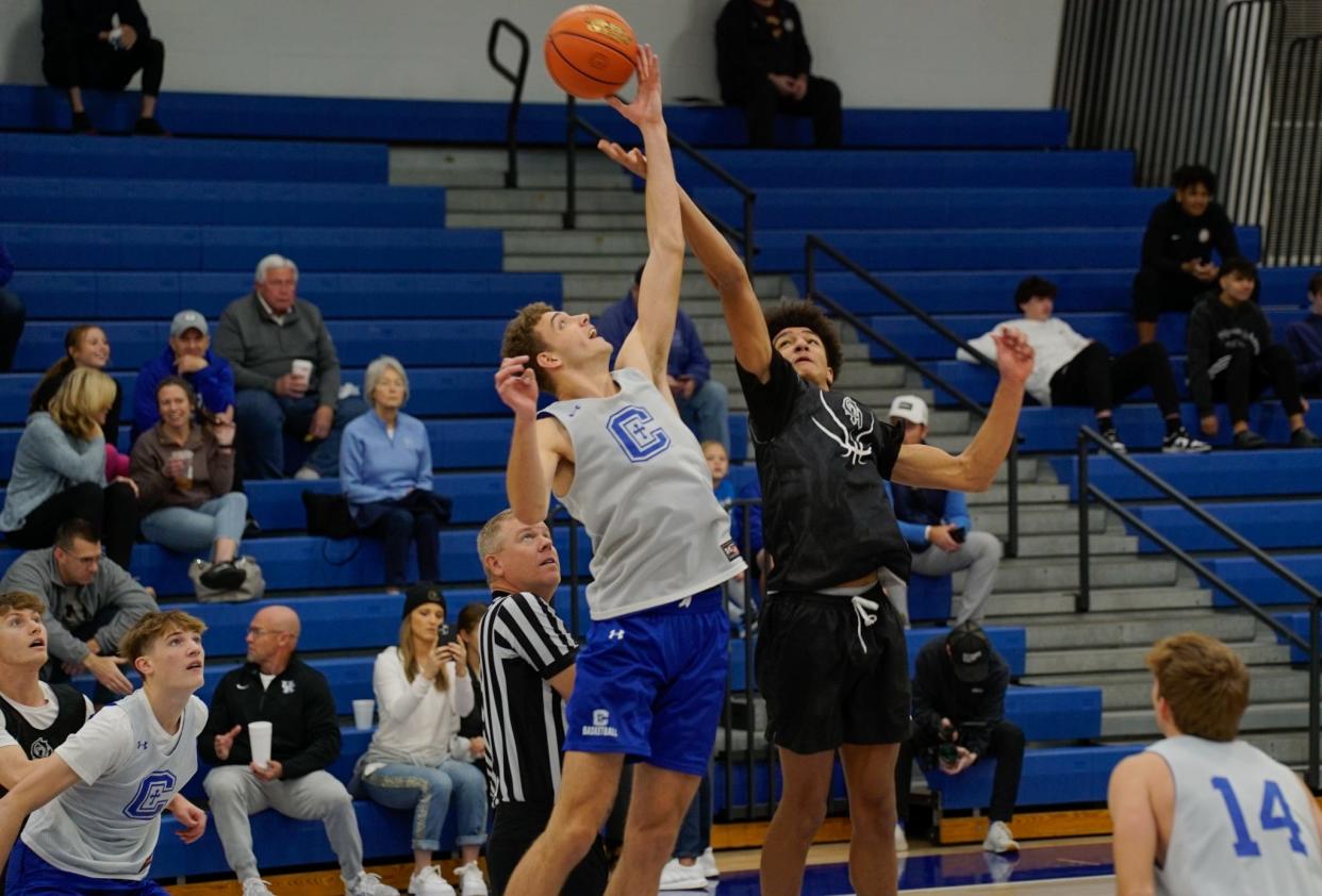 Covington Catholic's Caden Miller (left) and Oak Hills' Nate Riep battle for the opening tip during a game between the Colonels and the Highlanders at the Kelsey Sorrell Memorial Scrimmages at Simon Kenton High School on Nov. 18, 2023.