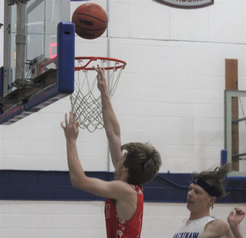 Onaway senior forward Bridger Peel (13) goes up strong for a layup during the second half at Mackinaw City on Thursday.