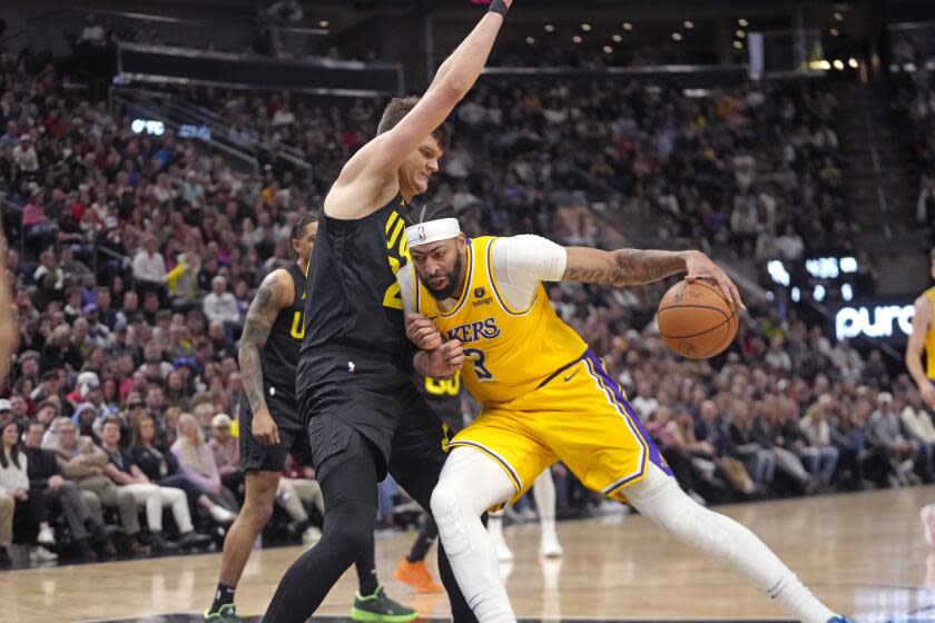 Utah Jazz center Walker Kessler, left, defends against Los Angeles Lakers forward Anthony Davis (3) during the first half of an NBA basketball game Wednesday, Feb. 14, 2024, in Salt Lake City. (AP Photo/Rick Bowmer)