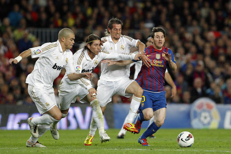 FILE - Barcelona's Lionel Messi from Argentina, right, duels for the ball with Real Madrid's Pepe from Portugal, left, Sergio Ramos and Fabio Coentrao of Portugal, center right, during a Spanish La Liga soccer match at the Camp Nou stadium, in Barcelona on April 21, 2012. Lionel Messi says he is coming to Inter Miami and joining Major League Soccer. After months of speculation, Messi announced his decision Wednesday, June 7, 2023,to join a Miami franchise that has been led by another global soccer icon in David Beckham since its inception but has yet to make any real splashes on the field. (AP Photo/Daniel Ochoa de Olza, File)