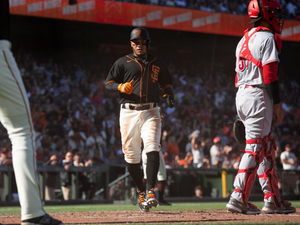 Jun 25, 2022; San Francisco, California, USA; San Francisco Giants shortstop Thairo Estrada (center) scores on an RBI double by Tommy LaStella (not pictured) against the Cincinnati Reds during the fourth inning at Oracle Park. Mandatory Credit: D. Ross Cameron-USA TODAY Sports