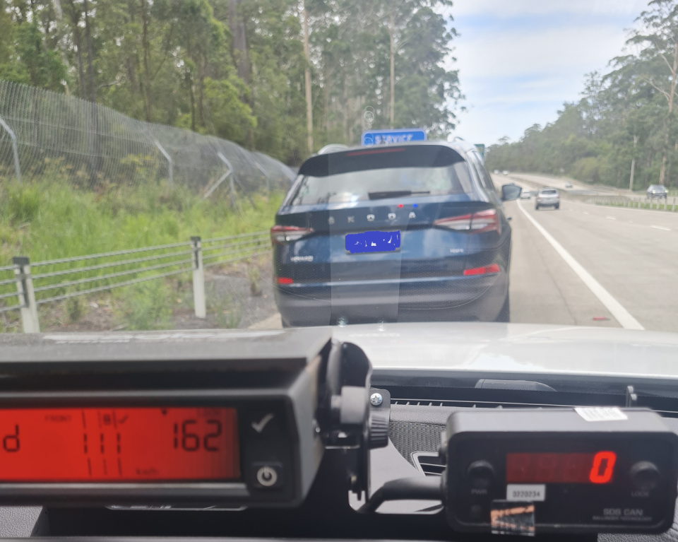The driver's blue Skota SUV on the side of the Pacific Highway after he was stopped for speeding with his kids in the car. 
