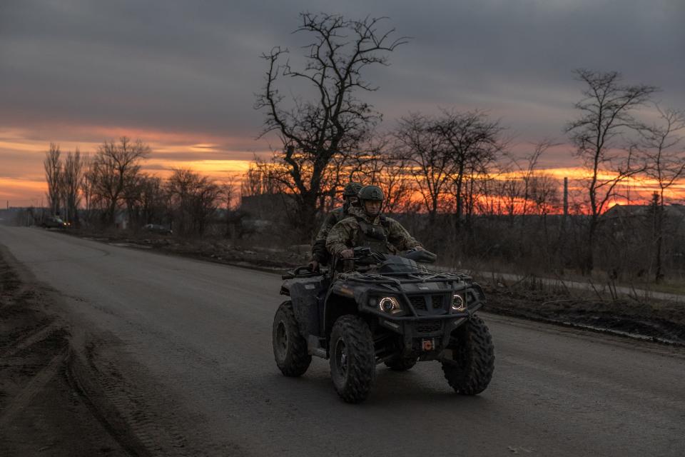 Ukrainian servicemen drive a quad bike on a road that leads to the town of Chasiv Yar, in the Donetsk region, on March 30, 2024.
