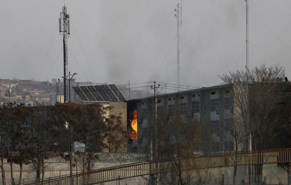 Flames rise from a government building after an explosion and attack by gunmen, in Kabul, Afghanistan, Monday, Dec. 24, 2018. (AP Photo/Rahmat Gul)