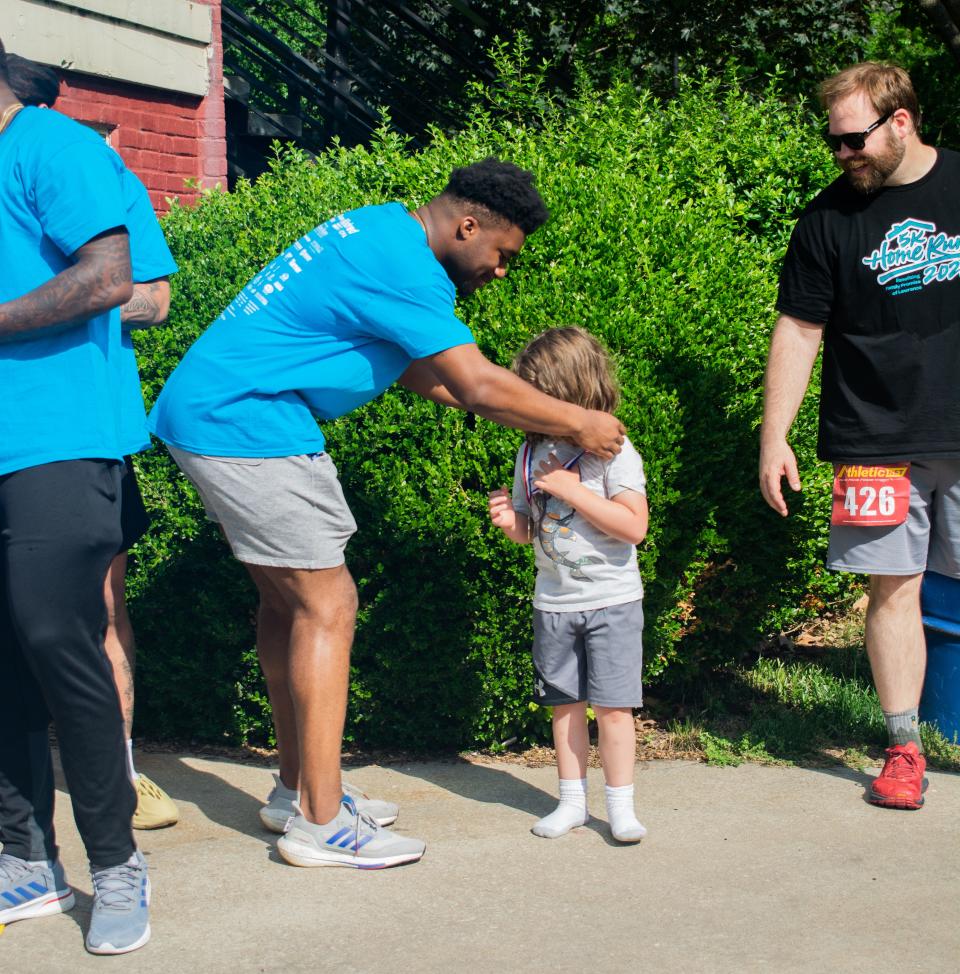 Kansas football player Devin Neal awards a medal during the 5K Home Run supporting Family Promise of Lawrence earlier this year. Neal has shown an interest in his community, not just playing sports.