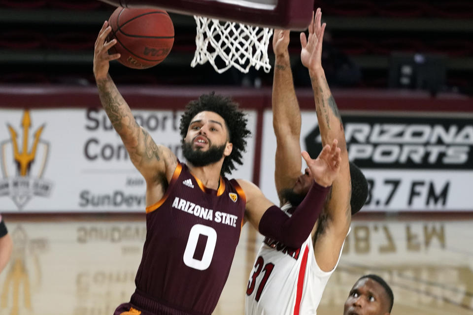 Arizona State guard Holland Woods (0) drives past Arizona guard Terrell Brown Jr. during the first half of an NCAA college basketball game Thursday, Jan. 21, 2021, in Tempe, Ariz. (AP Photo/Rick Scuteri)