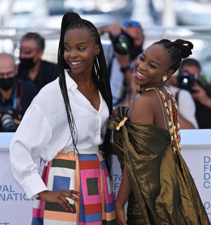 Two women smile and pose on the red carpet.