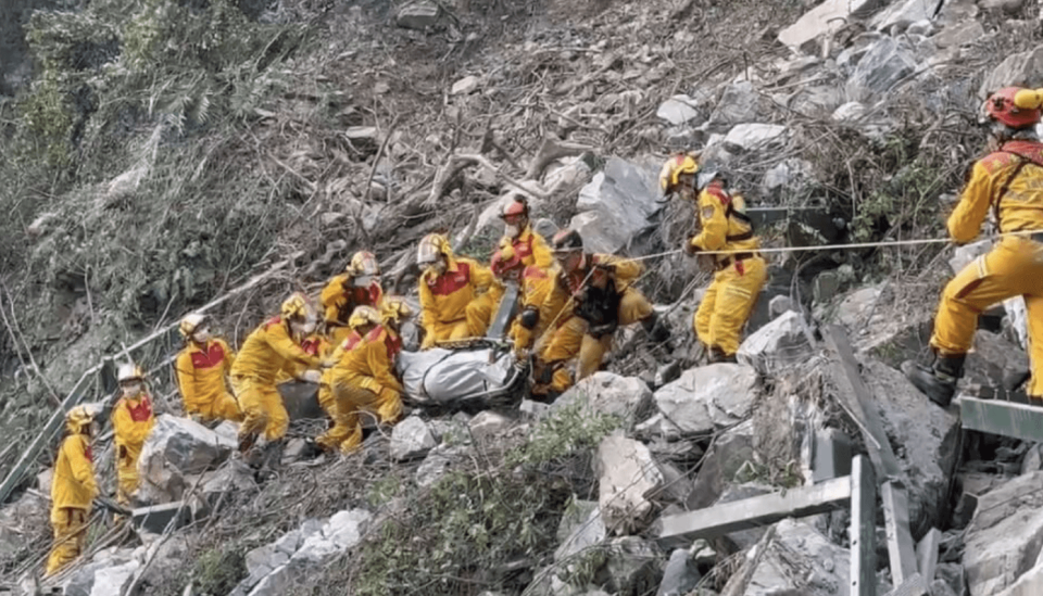 搜隊人員在小錐麓步道發現罹難男子，並以接力方式將遺體搬運下山。（屏東縣消防局提供）