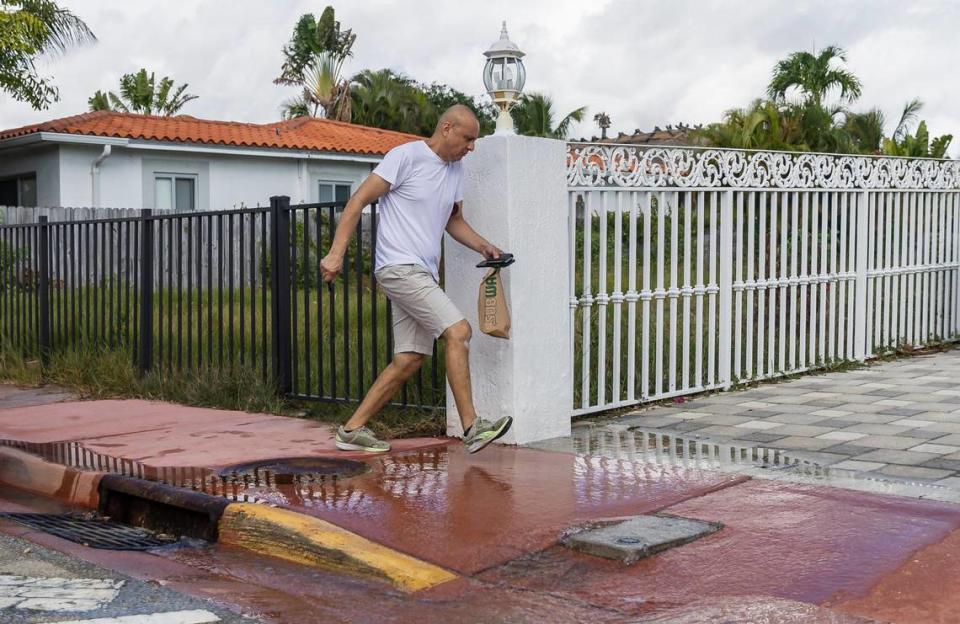 Ricardo tries to avoid a flow of water from the nearby Tatum Waterway on Monday, Oct. 30, 2023 in Miami Beach, Fla. Monday was the highest king tide of the year for South Florida, flooding streets, driveways and parks. MATIAS J. OCNER/mocner@miamiherald.com