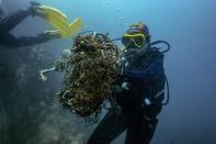 <p>En la fotografía, unos buzos recogen redes de pesca usadas del fondo del mar cerca de la costa de la provincia tailandesa de Chon Buri, al sur del país. (Foto: Lillian Suwanrumpha / AFP / Getty Images).</p> 