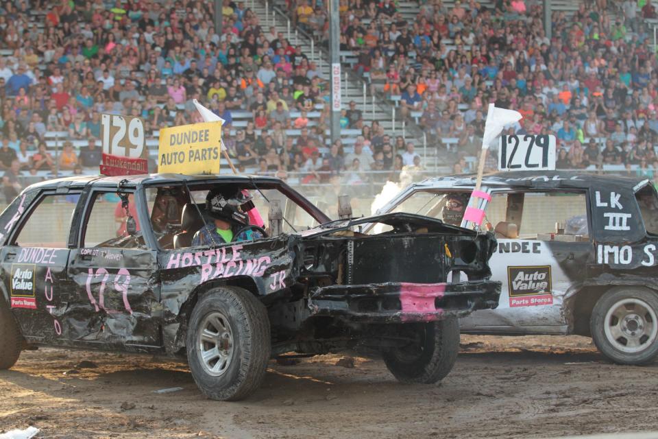 Mark Cuykendall (left #129) eyes up his dad, James Cuykendall (#1229), in the 6 p.m. feature event at the 2015 Monroe County Fair Demolition Derby.