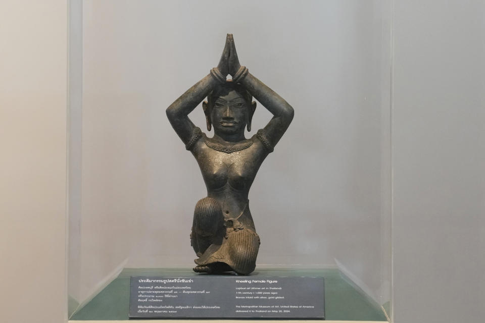 The ancient bronze kneeling woman sculpture is displayed during a repatriation ceremony at National Museum in Bangkok, Thailand, Tuesday, May 21, 2024. Thailand's National Museum hosted a welcome-home ceremony for two ancient statues that were illegally trafficked from Thailand by a British collector of antiquities and were returned from the collection of New York’s Metropolitan Museum of Art. The objects, a tall bronze figure called the “Standing Shiva” or the “Golden Boy” and a smaller sculpture called “Kneeling Female," are thought to be around 1,000 years old. (AP Photo/Sakchai Lalit)