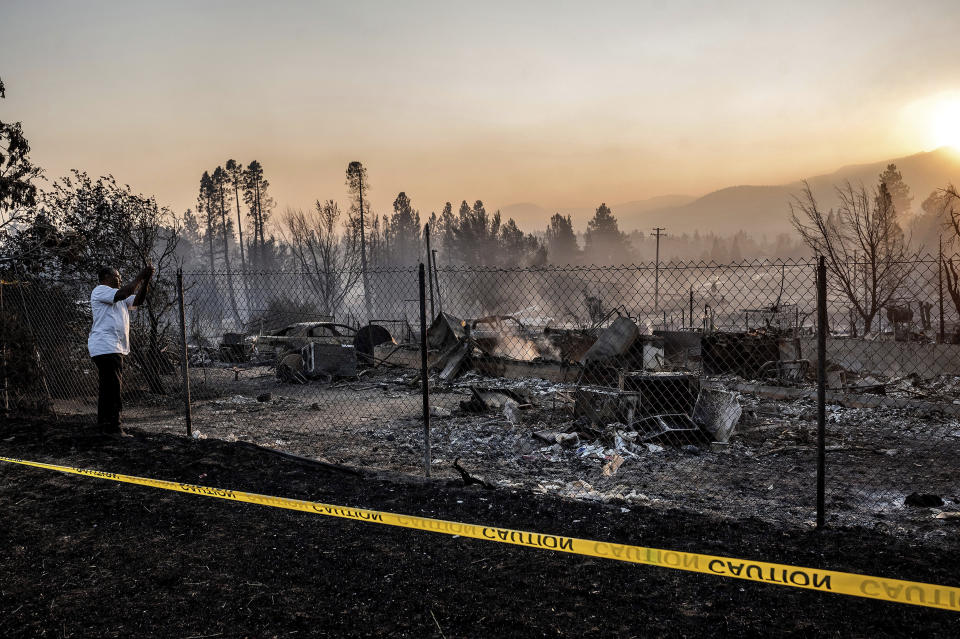 Dave Rodgers surveys his home, destroyed by the Mill Fire, on Saturday, Sept. 3, 2022, in Weed, Calif. Rodgers, who lived in the house his entire life, was able to take an elderly neighbor with him as he fled the fast-moving blaze but has not been able to find his two dogs that were left behind. (AP Photo/Noah Berger)