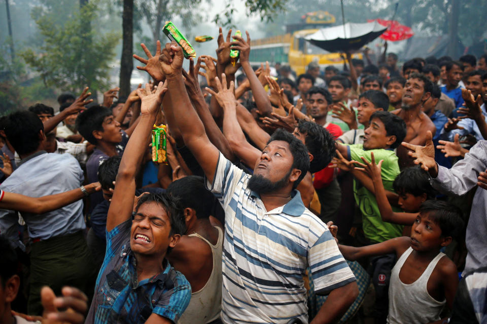 Rohingya refugees reach out their hands to grab aid packages in Cox's Bazar, Bangladesh, on Sept. 17, 2017.