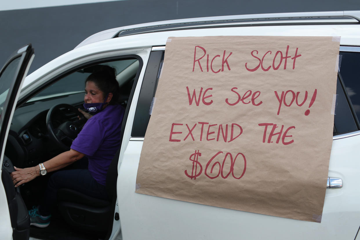 MIAMI SPRINGS, FLORIDA - JULY 16: A car with, 'Rick Scott We See You! Extend the $600!', on it participates in a caravan protest on July 16, 2020 in Miami Springs, Florida.  The caravan was driving to the Coral Gables office of Sen. Rick Scott to ask him and other Senators to support the new Schumer/Wyden legislation that extends unemployment benefits for all laid-off Americans as the coronavirus pandemic continues to disrupt the economy.  (Photo by Joe Raedle/Getty Images)