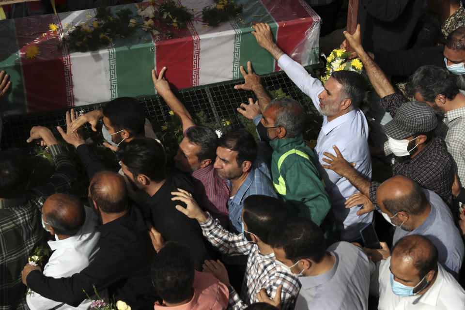 Mourners follow a truck carrying the flag draped coffin of Iran's Revolutionary Guard Col. Hassan Sayyad Khodaei who was killed on Sunday, in his funeral ceremony in Tehran, Iran, Tuesday, May 24, 2022. Iran's hard-line President Ebrahim Raisi vowed revenge on Monday over the killing of Sayyad Khodaei who was shot at his car by two assailants outside his home in Tehran, a still-mysterious attack on the country's powerful paramilitary force. (AP Photo/Vahid Salemi)