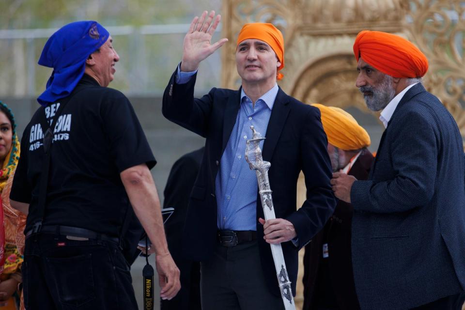 Canadian prime minister Justin Trudeau waves to the crowd after receiving the gift of  a ceremonial sword from Sikhs in Ontario (AP)