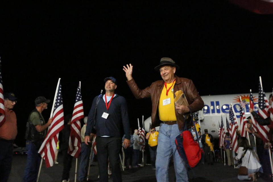 A veteran waves to the crowds of people who lined up to welcome the veterans home in Tallahassee, April 27, 2024.