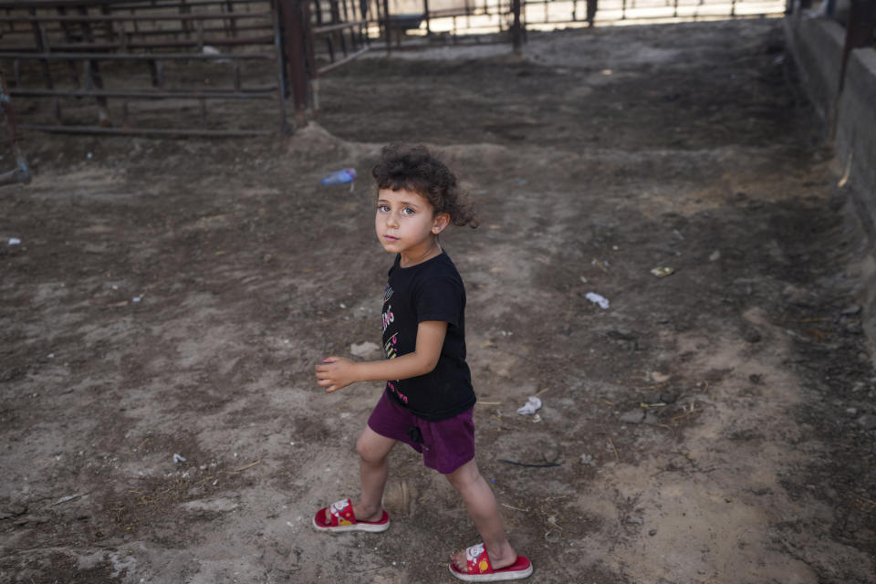 Un niño palestino camina por establos de animales vacíos antes de la fiesta del Eid al-Adha, en Jan Yunis, Franja de Gaza, el 10 de junio de 2024. Tras ocho meses de devastadora guerra entre Israel y Hamás, es difícil encontrar carne o ganado vivo en los mercados locales. (AP Foto/Abdel Kareem Hana)