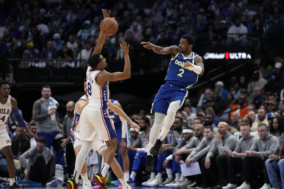 Dallas Mavericks guard Kyrie Irving (2) makes a pass as Philadelphia 76ers' De'Anthony Melton (8) defends in the first half of an NBA basketball game, Thursday, March 2, 2023, in Dallas. (AP Photo/Tony Gutierrez)