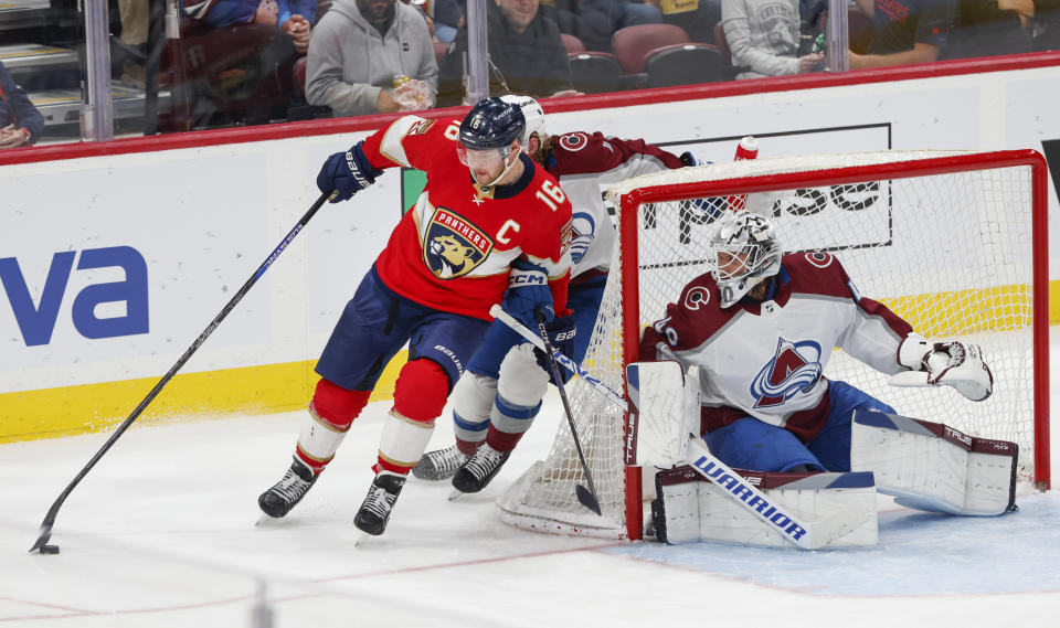 Florida Panthers center Aleksander Barkov (16) drives the puck past Colorado Avalanche defenseman Bowen Byram (4) and goaltender Alexandar Georgiev (40) during the third period of an NHL hockey game Saturday, Feb. 11, 2023, in Sunrise, Fla. (AP Photo/Reinhold Matay)