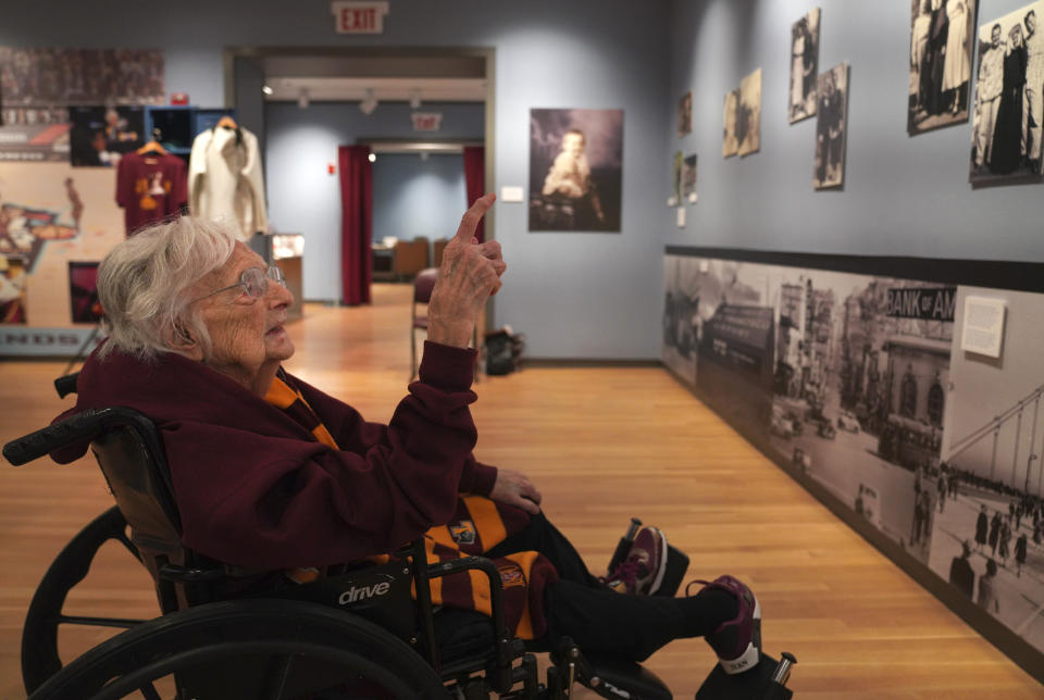 Sister Jean Dolores Schmidt looks at family photos hanging in a museum gallery dedicated to the now 103-year-old Catholic nun, at Loyola University on Tuesday, Jan. 24, 2023, in Chicago. (AP Photo/Jessie Wardarski)