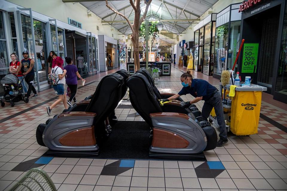 Janitor Linda Figueroa sanitizes massage chairs in the Yuba Sutter Mall on Wednesday, May 6, 2020 in Yuba City. She circles the mall constantly cleaning and disinfecting. It was the first day the mall was open after county health officials allowed retail stores to reopen in defiance of the state’s stay-at-home order to slow the spread of the coronavirus.