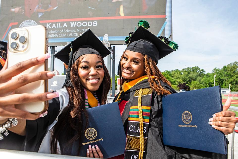 Graduates take a selfie with their diplomas at the conclusion of the Delaware State University 2023 commencement ceremony at Alumni Stadium in Dover, Friday, May 12, 2023.