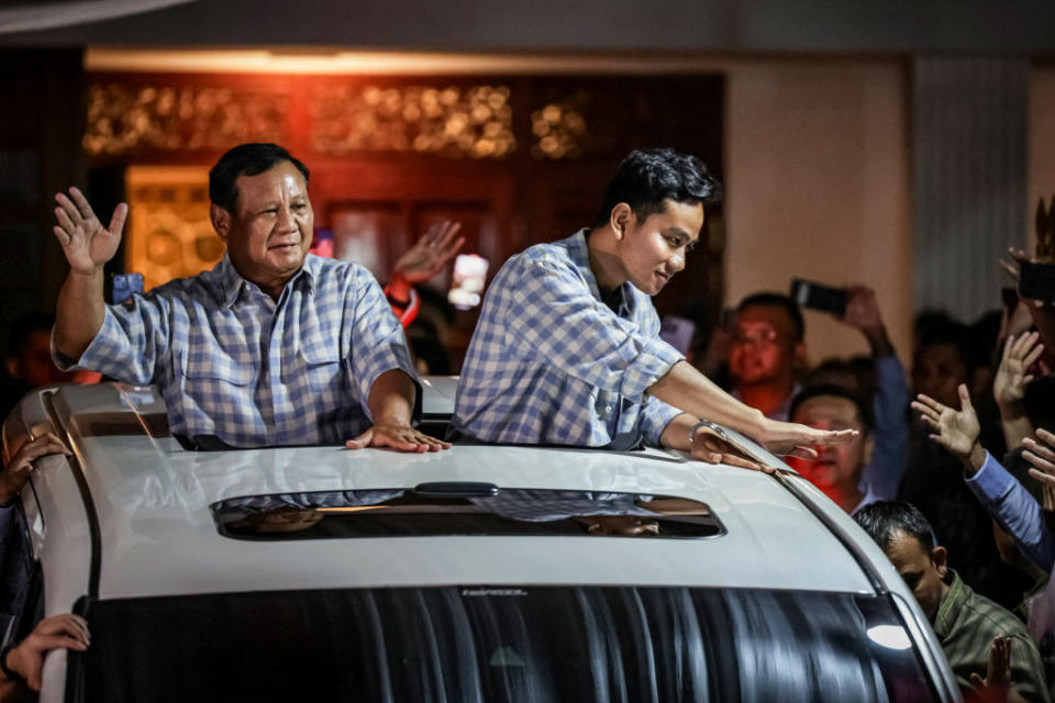 Presidential candidate Prabowo Subianto and vice presidential candidate Gibran Rakabuming Raka, outgoing President Joko Widodo’s son, wave to supporters from a car as they head to a rally after the polls closed in Jakarta on Feb. 14, 2024.<span class="copyright">Yasuyoshi Chiba—AFP/Getty Images</span>