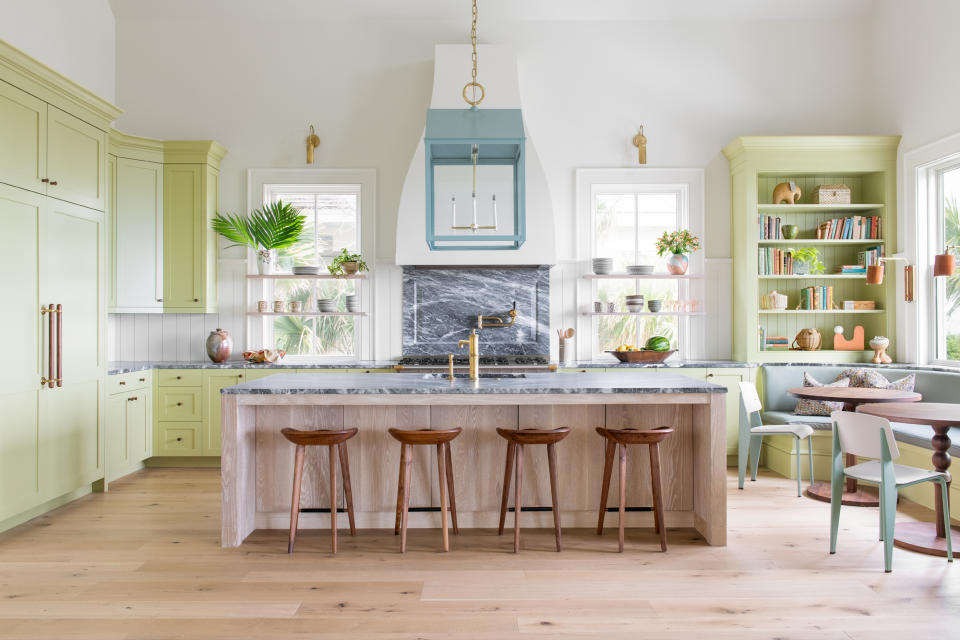 a pastel green and blue kitchen with a large island