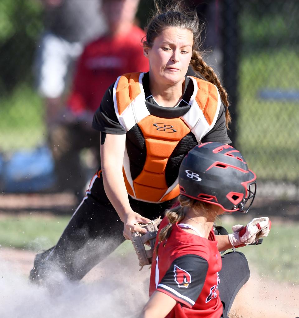 Marlington's Ava Collins attempts a tag on Jenna Triveri who was safe at home in the fifth inning of the Division II regional final, Friday, May 26, 2023, at Nordonia.