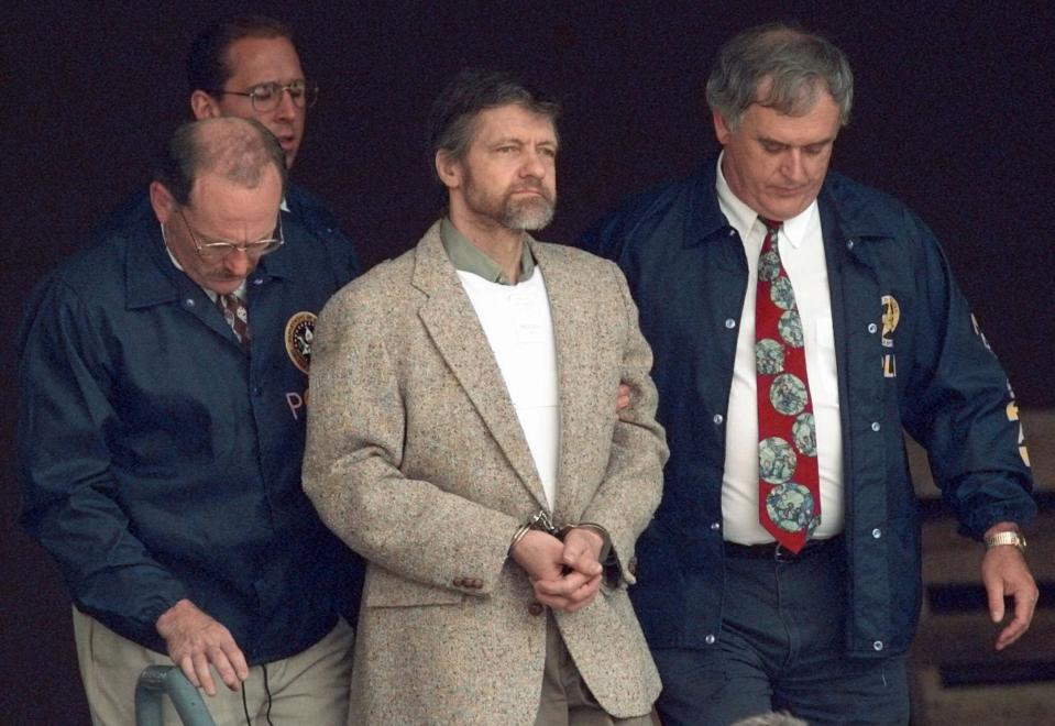 FILE - Theodore Kaczynski looks around as U.S. Marshals prepare to take him down the steps at the federal courthouse to a waiting vehicle on June 21, 1996, in Helena, Mont. A spokesperson for the Bureau of Prisons told The Associated Press that Kaczynski, known as the “Unabomber,” has died in federal prison. The cause of death was not immediately known. (AP Photo/Elaine Thompson, File)