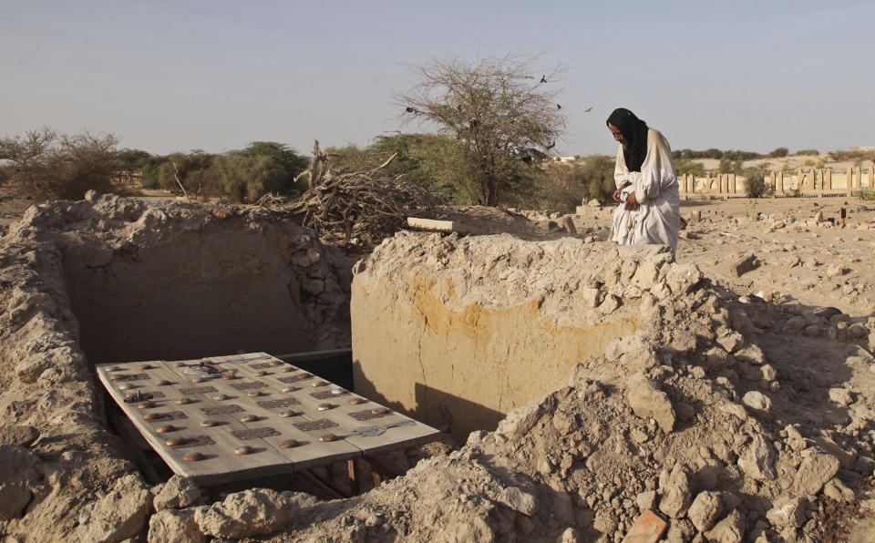 FILE - Mohamed Maouloud Ould Mohamed, a mausoleum caretaker, prays at a damaged tomb in Timbuktu, Mali, April 4, 2014. The International Criminal Court unsealed an arrest warrant Friday June 21, 2024, for a Malian accused of war crimes and crimes against humanity in the desert city of Timbuktu in 2012-13, where he is suspected of leading an al-Qaida-linked Islamic extremist group. (AP Photo/Baba Ahmed, File)