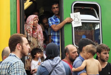 Migrants protest from inside a train at the railway station in the town of Bicske, Hungary, September 3, 2015. REUTERS/Bernadett Szabo