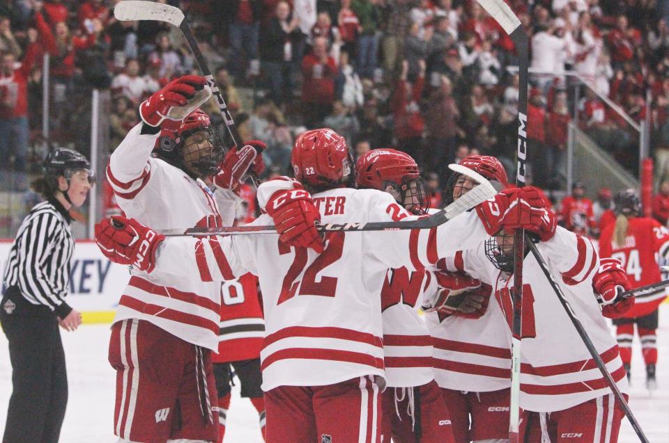 Wisconsin women's hockey players surround Sarah Wozniewicz after she scored a goal early in the third period of the Badgers' 4-0 victory over St. Lawrence in a NCAA regional final Saturday at LaBahn Arena in Madison.