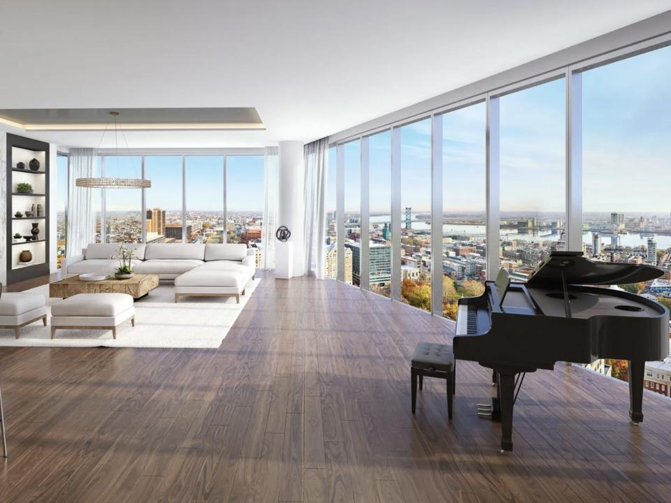 white furniture and a grand piano in a room with floor-to-ceiling windows in a penthouse in Pennsylvania